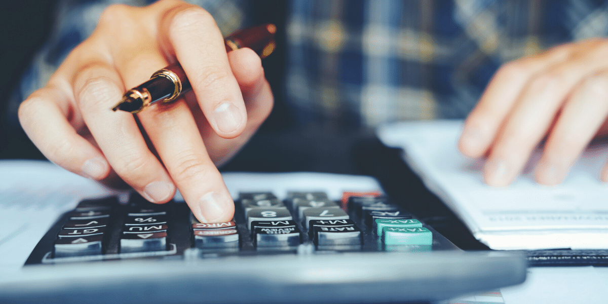 man using calculator and notepad